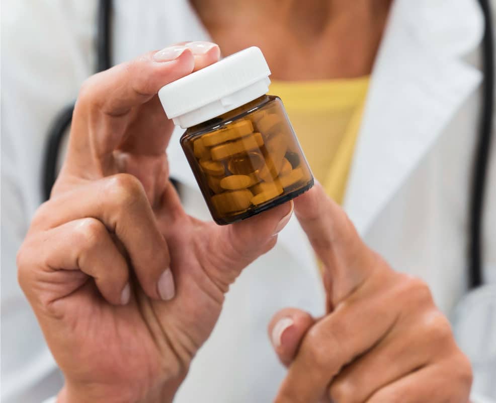 Profesional de la salud mostrando un frasco con suplementos terapéuticos, ejemplo de productos que requieren Registro Sanitario en Panamá para Suplementos Terapéuticos.
