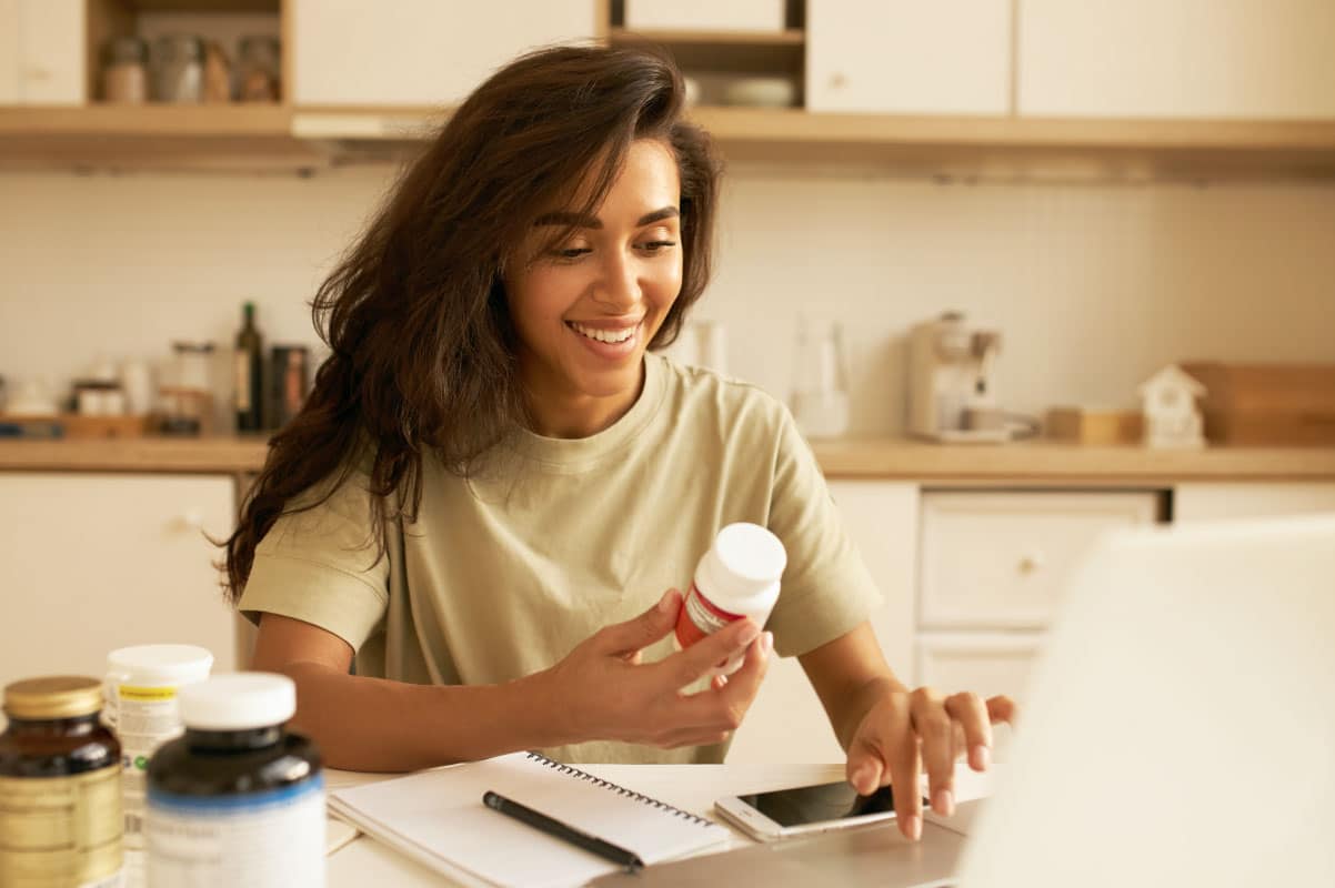 Mujer revisando suplemento terapéutico mientras consulta requisitos para el Registro Sanitario en Panamá para Suplementos Terapéuticos.