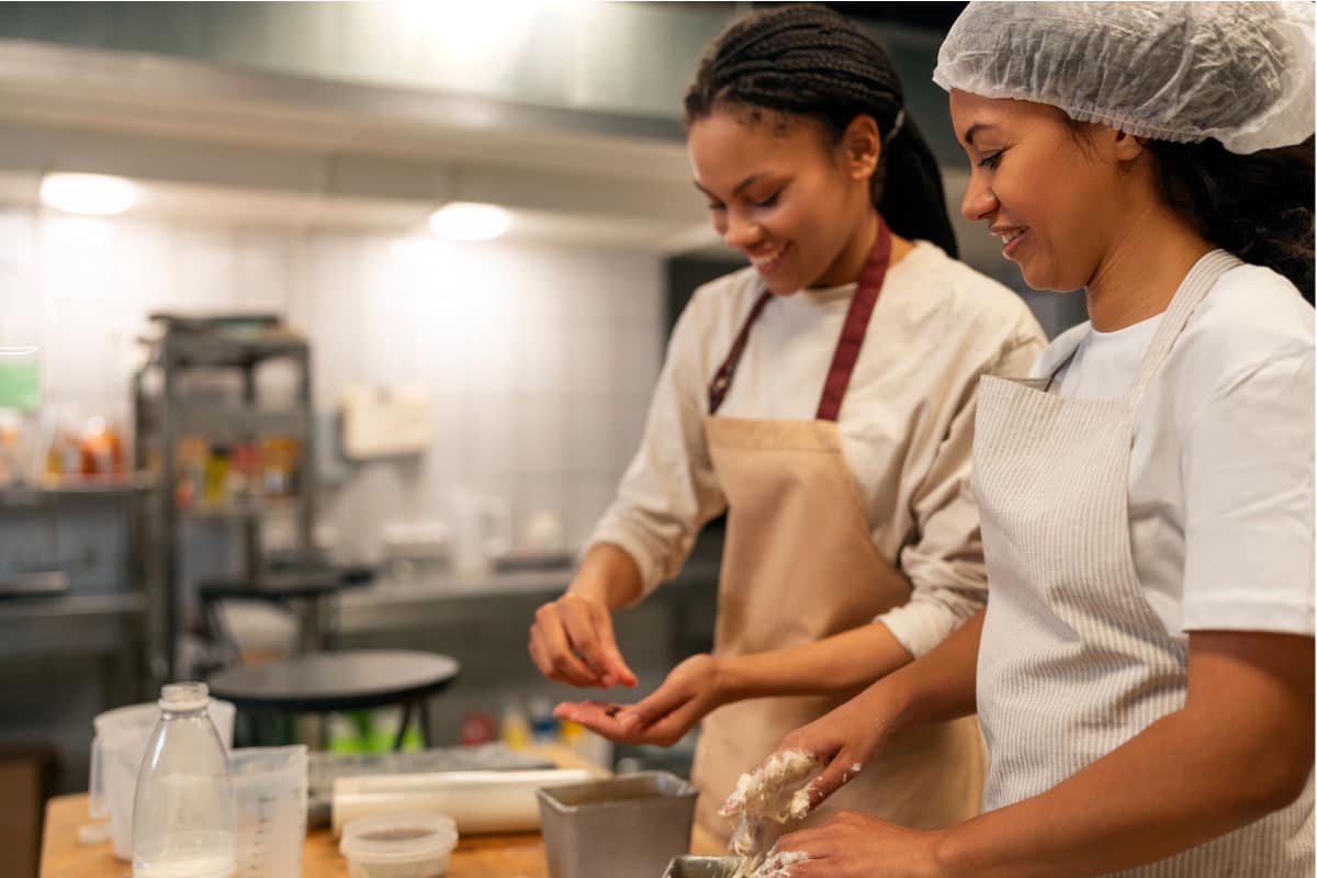Trabajadoras aplicando Buenas Prácticas de Manufactura en producción de alimentos con certificación BPM